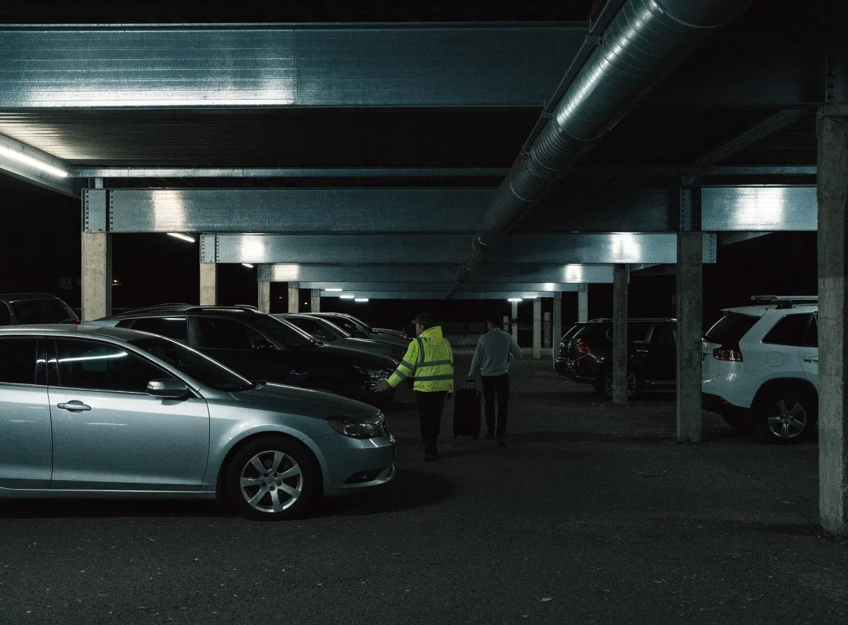 Covered off-airport parking rows at night